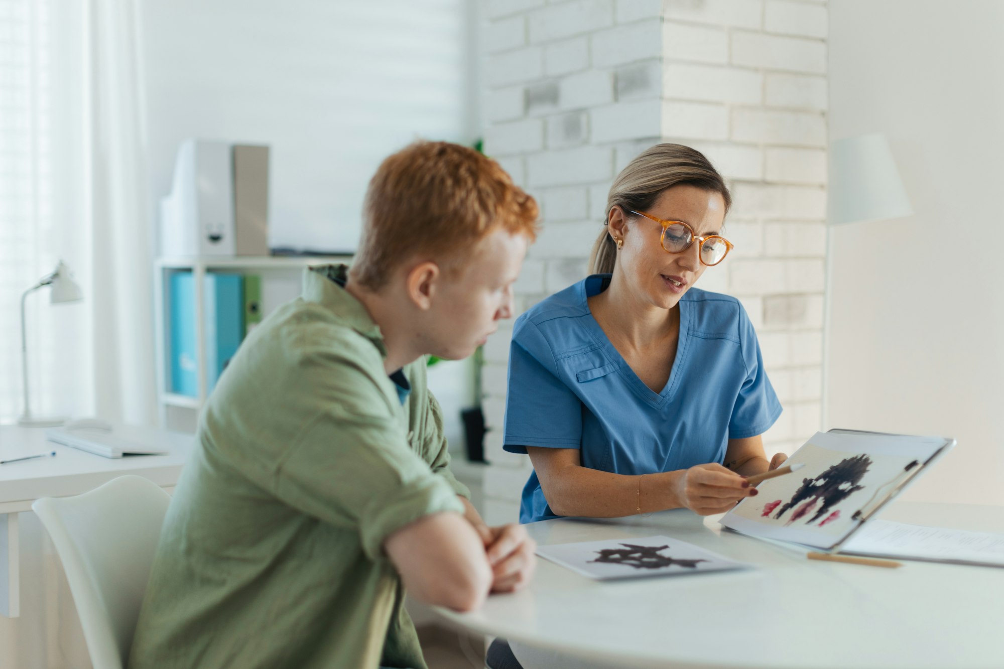 Teenager taking Rorschach test during psychological therapy with adolescent psychologist